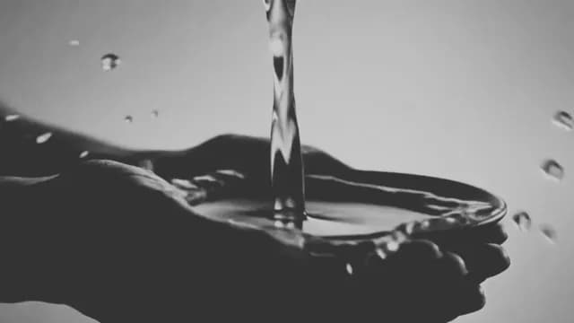 Cupped Hands Catching Flowing Water in Black and White