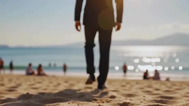 Businessman in Suit Walking on Sunny Beach Towards the Ocean