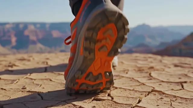 Hiker Walking on Cracked Desert Earth with Canyon Background