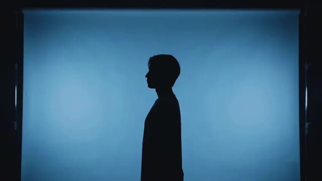 Silhouette Profile of a Man Against Blue Studio Backdrop