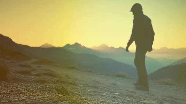 Silhouette of a Hiker Walking on Mountain Path at Golden Hour