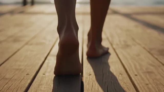 Bare Feet Walking on Wooden Pier at Golden Hour