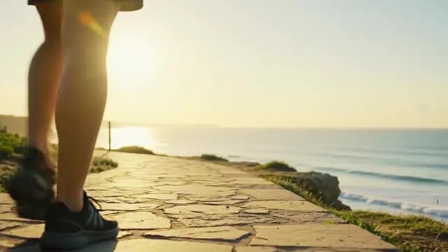 Runner Jogging Along Scenic Coastal Stone Path at Sunrise