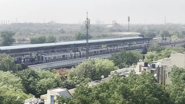 Delhi Metro Train Arriving at Elevated Station Over City Landscape
