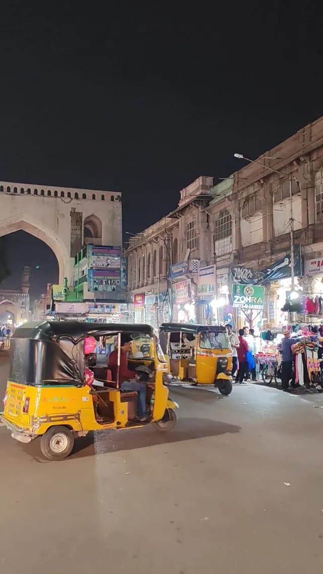 Vibrant Night Street Traffic with Auto Rickshaws near Charminar in Hyderabad India