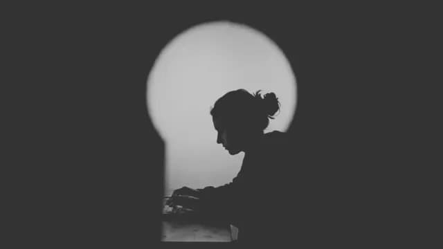 Silhouetted Woman Working at Computer with Minimalist Circular Lighting