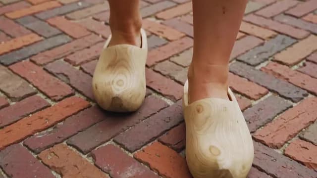 Person Walking in Traditional Dutch Wooden Clogs on Brick Path