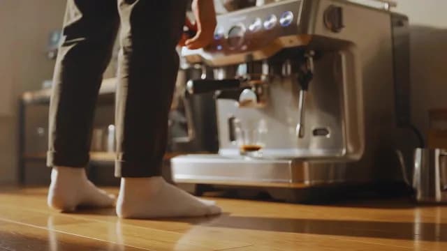 Person Brewing Fresh Morning Espresso with Professional Machine in Sunlit Kitchen