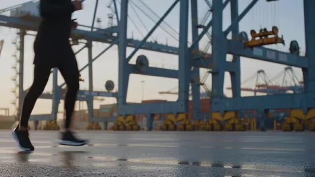 Athlete Running Through Industrial Shipping Port at Dawn