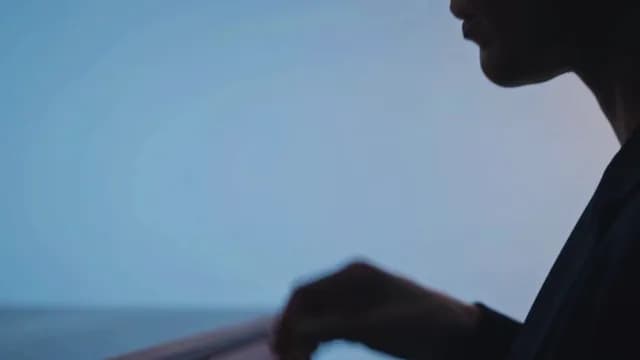 Silhouette of a Pensive Person Overlooking Calm Sea at Twilight