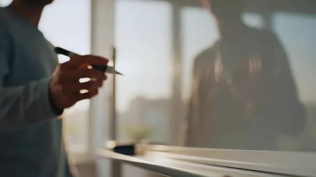 Businessman Preparing to Write on Whiteboard in Sunlit Office