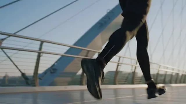 Athlete Jogging Across Modern City Bridge at Sunrise