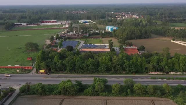 Aerial View of Industrial Solar Power Plant Along Rural Highway