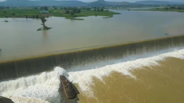 Aerial Shot of Water Cascading Over a Wide Spillway Rajdari Devdari Dam