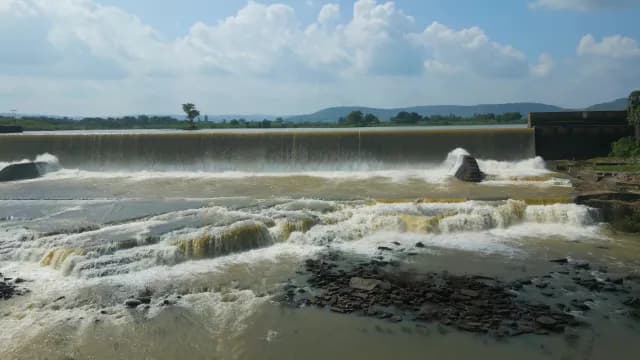 Scenic Rajdari Devdari Dam with Cascading Water and Mountain Backdrop