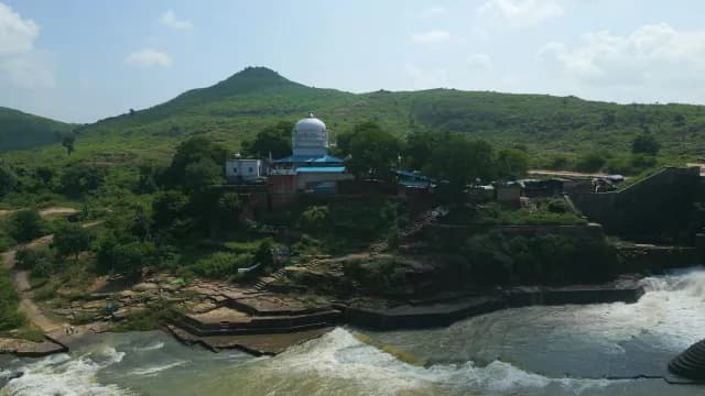Scenic Aerial View of White Temple by River and Mountains at Rajdari Devdari Dam
