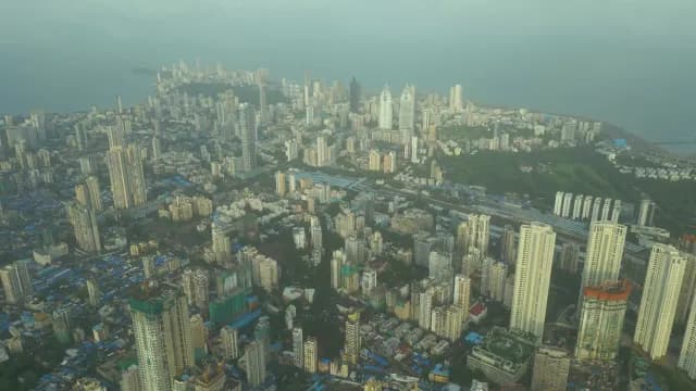 Aerial View of Dense Mumbai Skyline and Coastline Under Hazy Skies