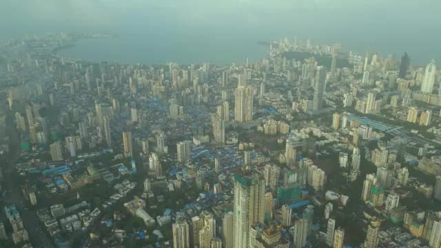 Aerial View of Mumbai Skyline and Coastal Cityscape Under Hazy Sky