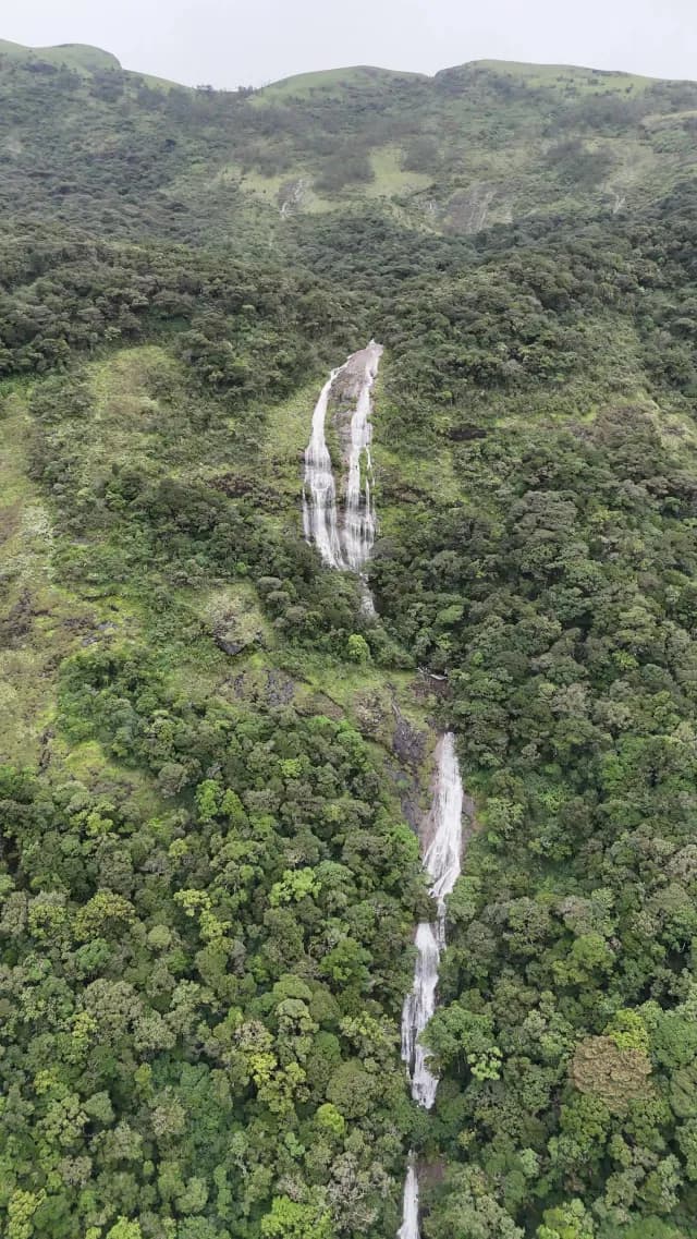 Aerial View of Scenic Nayamakkad Waterfall Cascading Through Lush Mountain Forest in Munnar