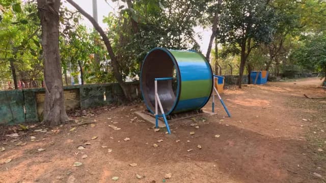 Colorful Metal Human Hamster Wheel in Shaded Public Park