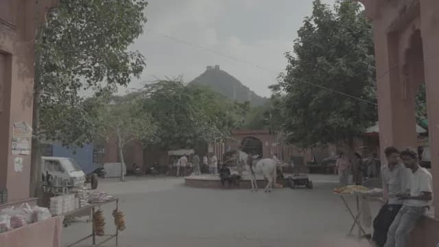 Bustling Indian Plaza with White Horse and Hilltop Temple View
