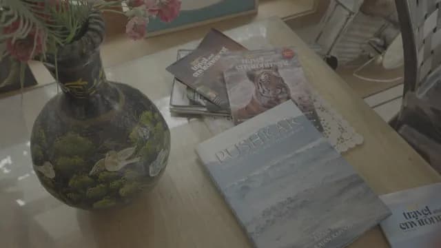 Decorative Vase with Travel Books and Magazines on Table