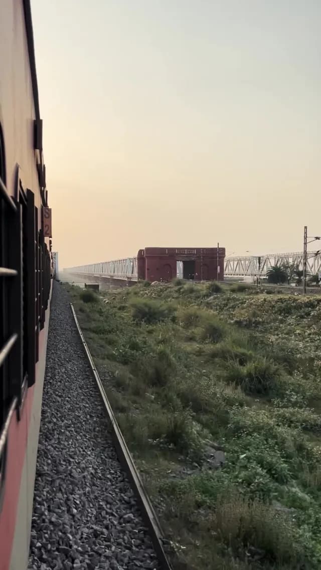 Indian Train Journey Approaching Historic Bridge at Sunset