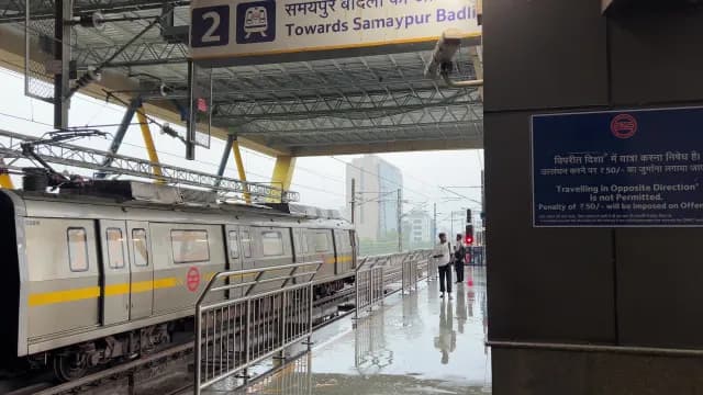 Delhi Metro Train Arriving at Elevated Station on Rainy Day