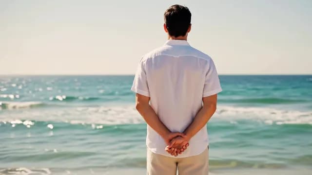 Man in White Linen Shirt Gazing at Sunny Ocean Horizon