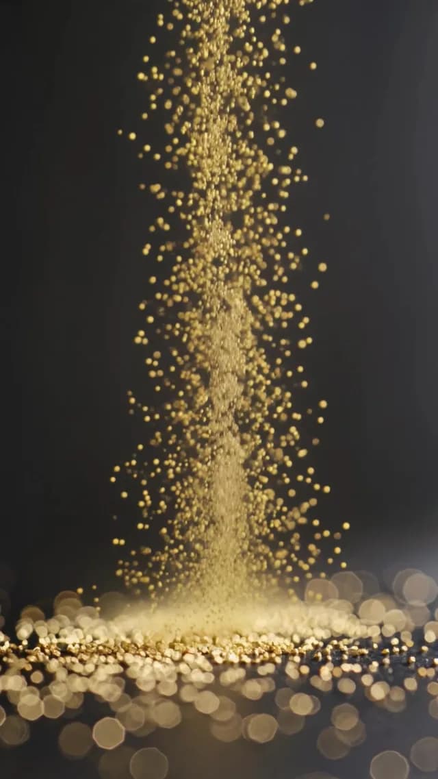 Golden Glitter Grains Falling on Black Background