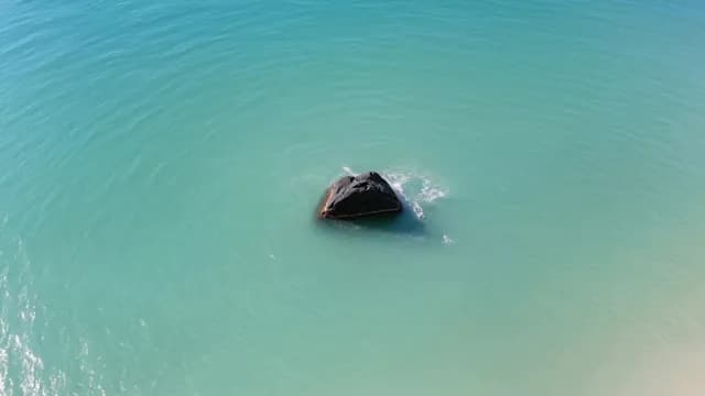 Aerial View of Solitary Rock in Turquoise Tropical Ocean Water