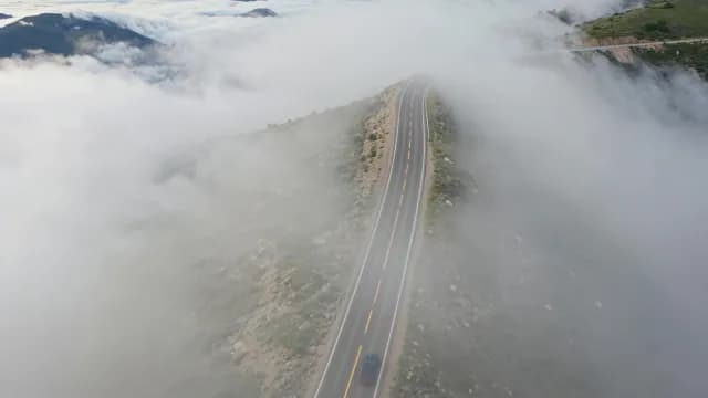Aerial View of Scenic Mountain Road Above Thick Clouds