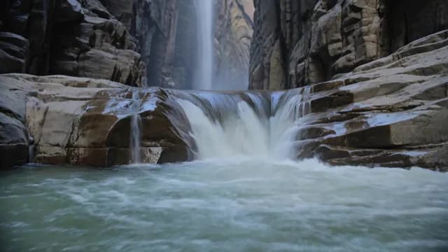 Majestic Waterfall Cascading Through Deep Rocky Canyon Gorge