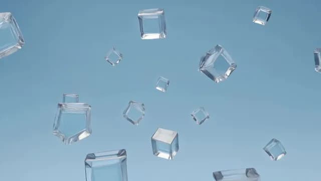 Falling Clear Ice Cubes Against Minimalist Blue Background