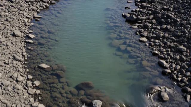 Aerial Shot of Clear Shallow River with Rocky Bed