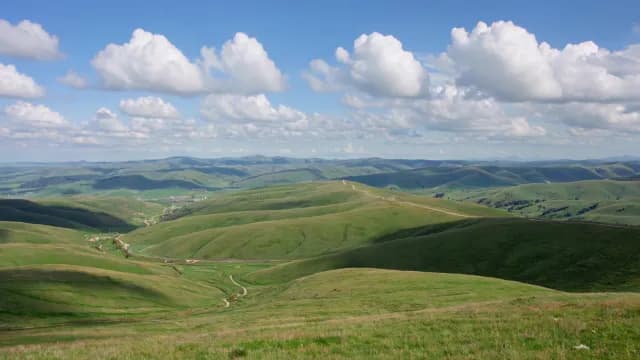 Panoramic View of Rolling Green Hills under Sunny Blue Sky