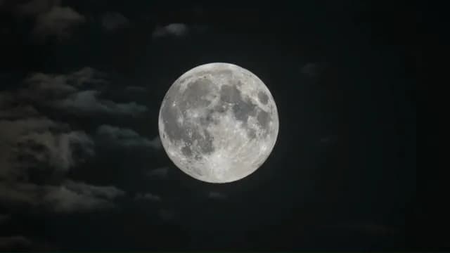 Glowing Full Moon Shining Through Dark Wispy Clouds at Night