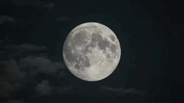 Luminous Full Moon Glowing in Dark Night Sky with Wispy Clouds