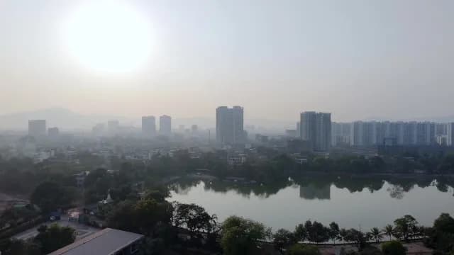 Aerial View of Hazy Sunrise Over Urban Lake, Fields and City Skyscrapers at Dombivli, Maharashtra
