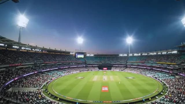 Professional Cricket Match at Stadium Under Floodlights and Batsman Hitting it Out of the Park