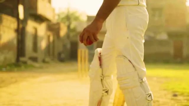 Close-up of Cricket Player Holding Red Ball During Street Match