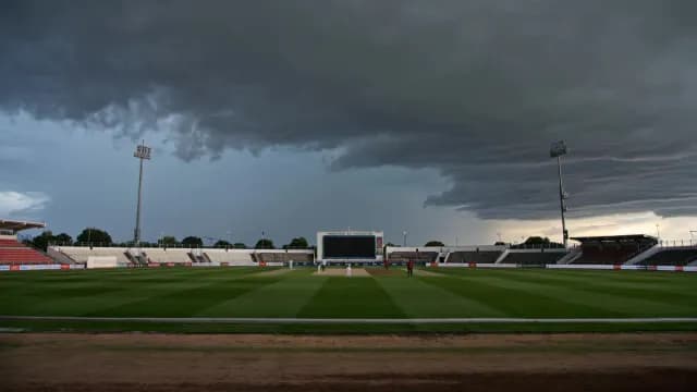 Cricket Match Under Dramatic Storm Clouds in Professional Stadium