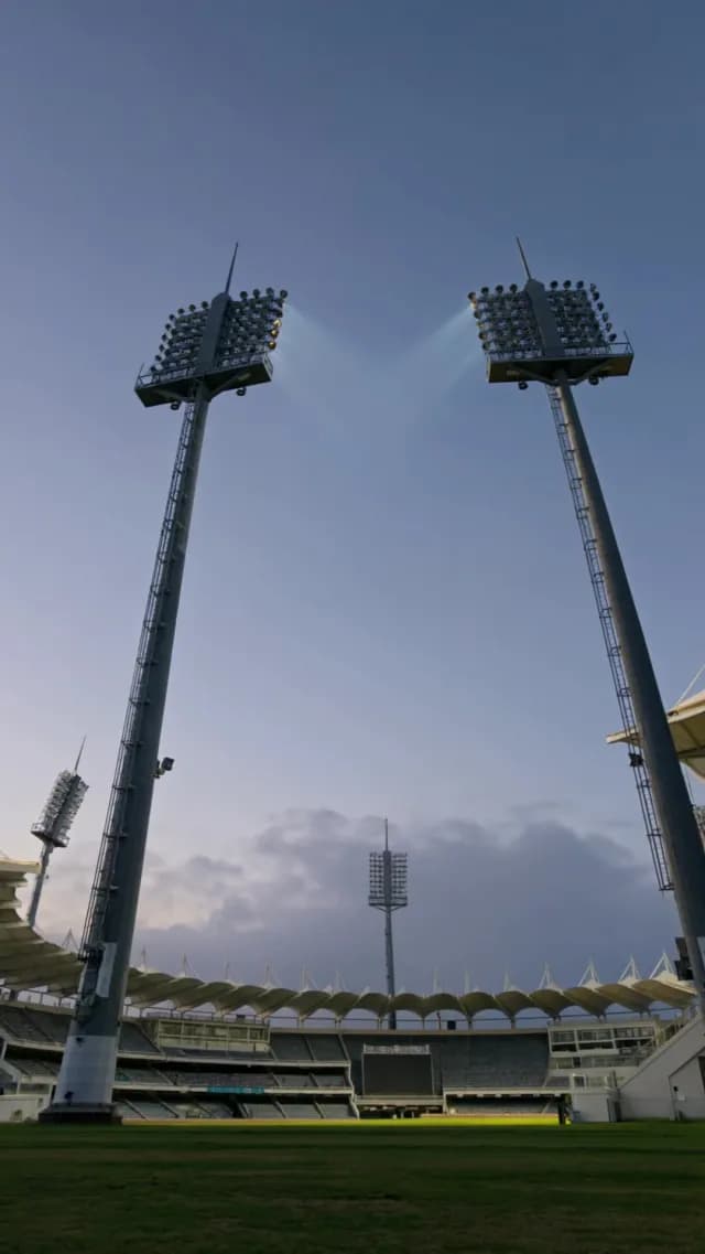 Tall Floodlights Over Empty Sports Stadium at Twilight