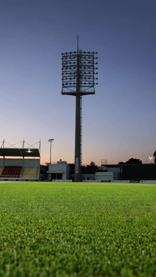 Empty Sports Stadium with Towering Floodlights at Twilight