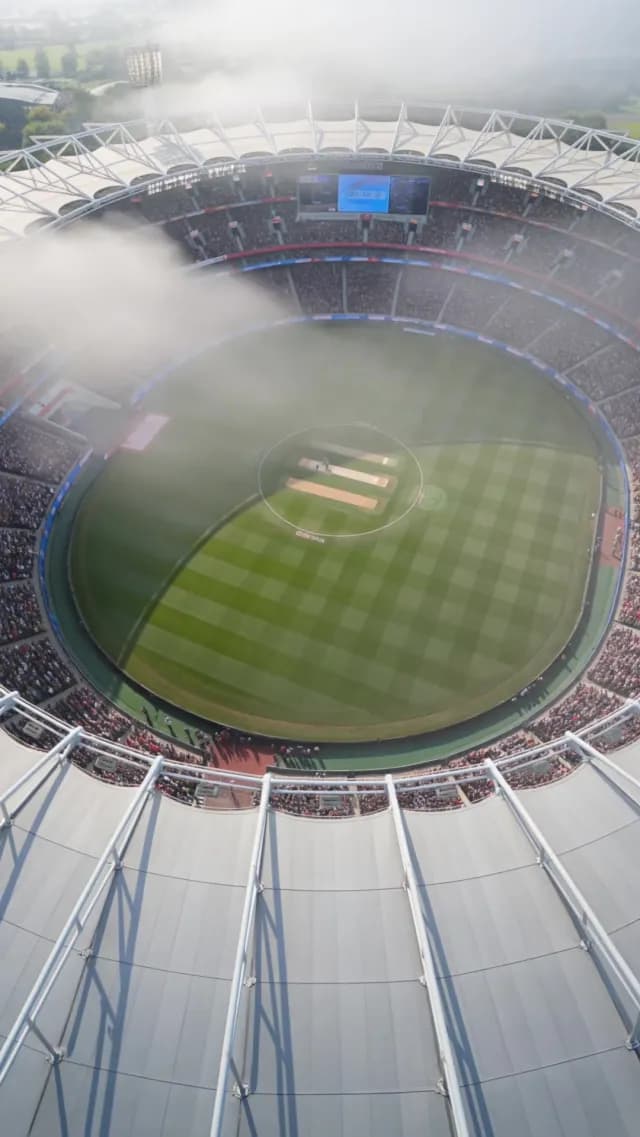 Aerial View of Misty Cricket Stadium During Match