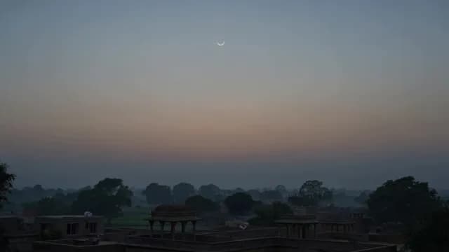 Crescent Moon Over Ancient Indian Architecture at Dawn