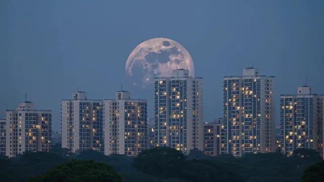 Massive Supermoon Rising Behind City Apartment Buildings
