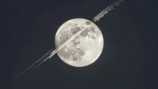 Clouds Crossing Large Full Moon with Visible Vapor Trails