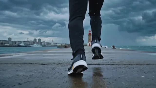Runner Jogging Towards Lighthouse on Stormy Pier in Geneva Switzerland
