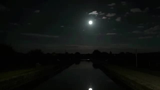 Bright Full Moon Reflecting in Calm Canal Water at Night